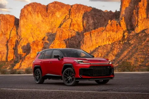 Red Toyota RAV4 Hybrid parked in front of Arizona's Superstition Mountains, illustrating Toyota RAV4 hybrid battery replacement and hybrid ownership in Arizona.