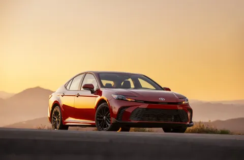 Red Toyota Camry on an Arizona desert road at sunset.