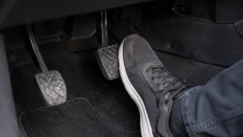 Driver pressing a brake pedal that is sinking toward the floor.